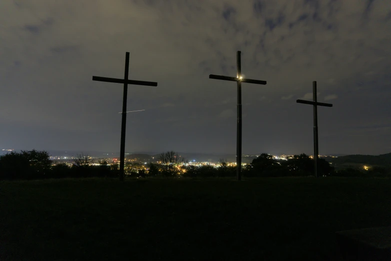 a group of three crosses standing on a hill
