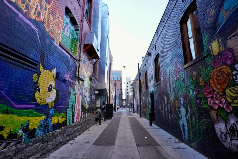 a road and a street wall filled with graffiti