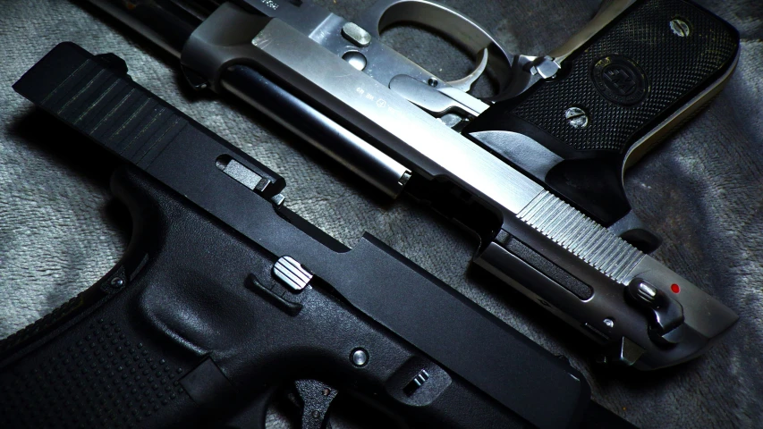 a metal gun laying on top of a black leather material