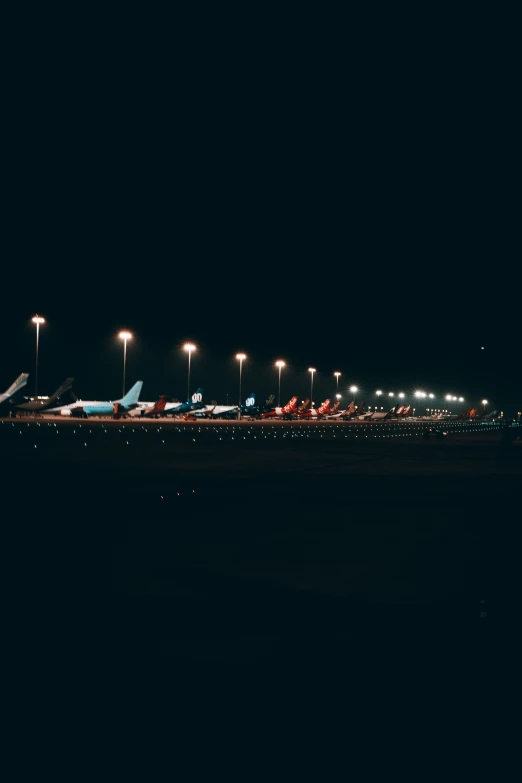 an airport at night with several planes all lit up