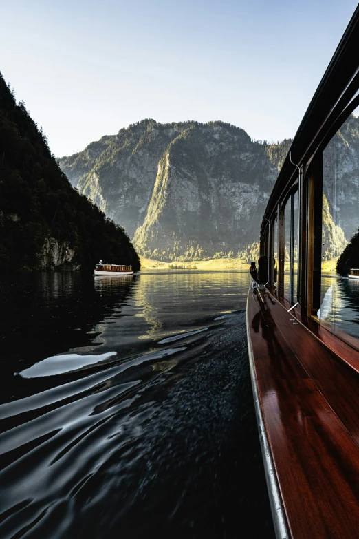 a boat in the middle of some water with a mountain in the background