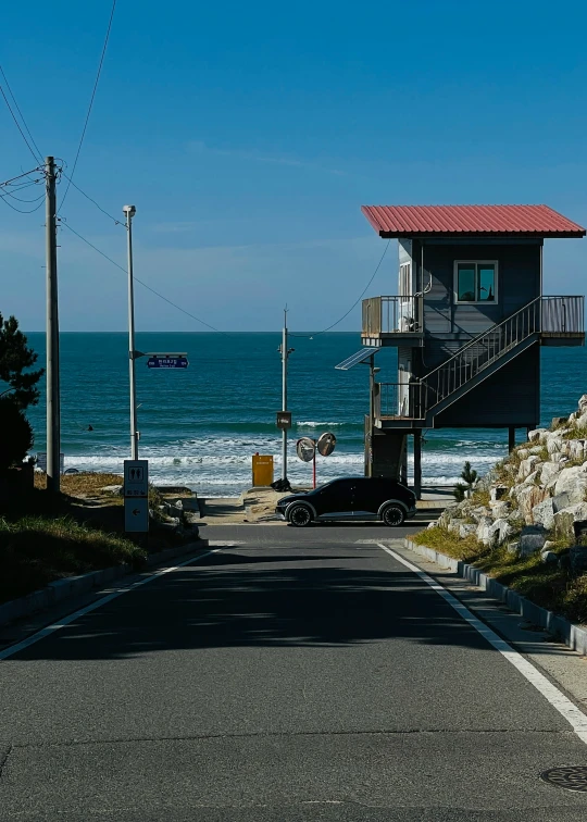 a road with a house in it near the ocean