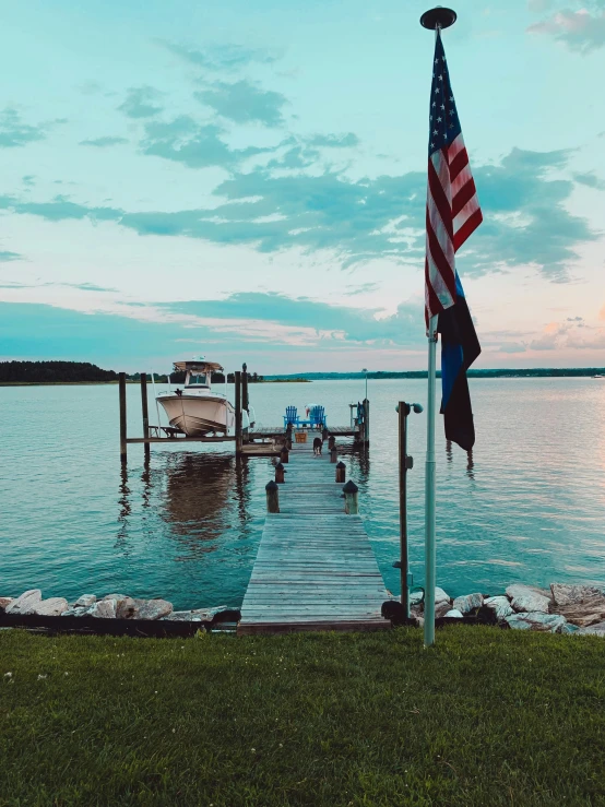 a boat sits docked with a flag flying above it