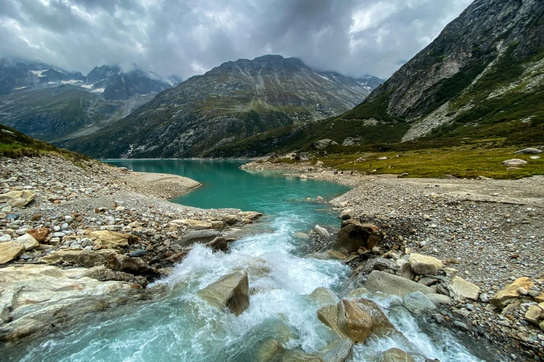 a beautiful view of a stream running between mountains