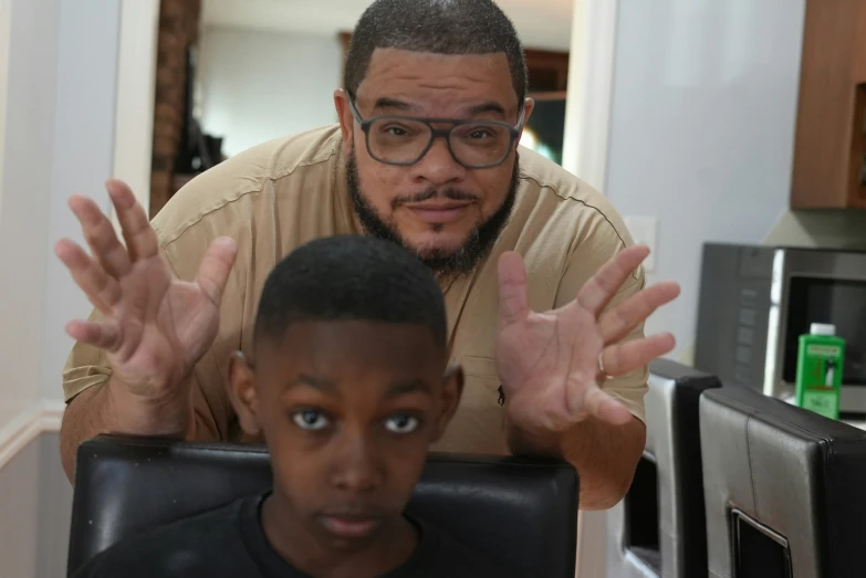 a man is trying to use his computer as a child looks on