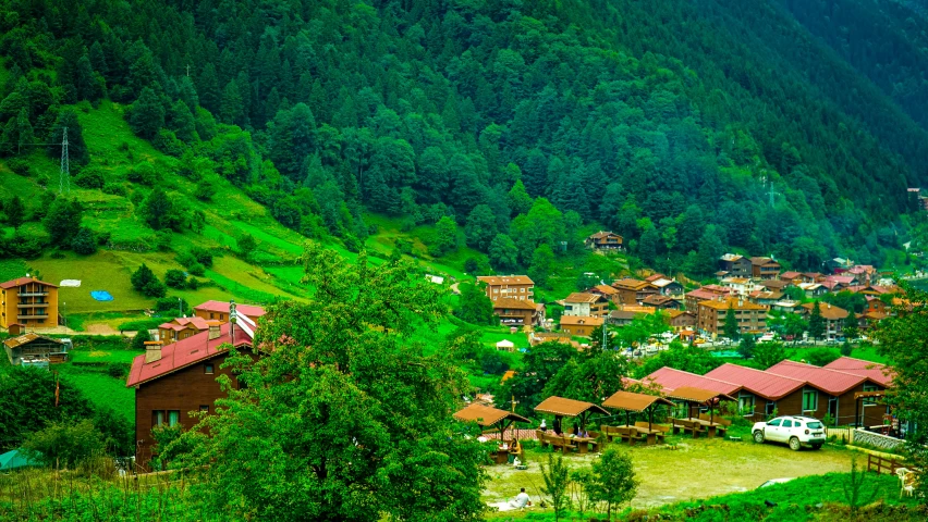 a large group of buildings in the middle of a green hillside