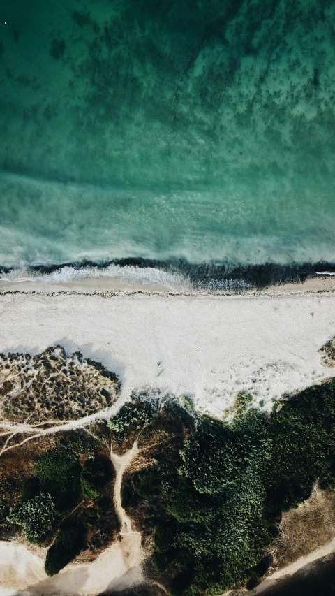 an overhead view of a beach, and the blue water