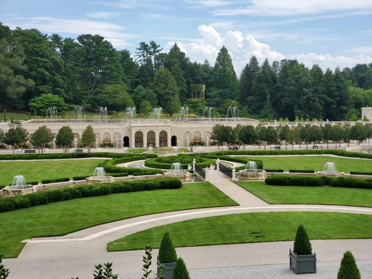 a garden surrounded by green grass, bushes and hedges