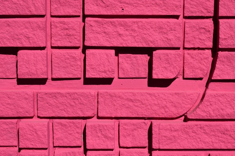 the texture of the cement against the bright pink wall