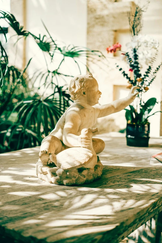 statue of small angel with outstretched wings sitting on table