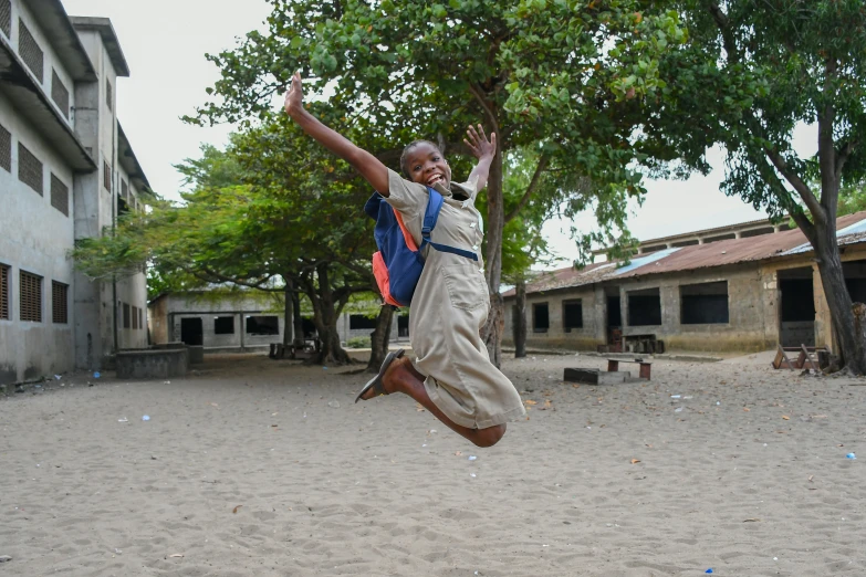 a boy jumps up in the air in his school uniform