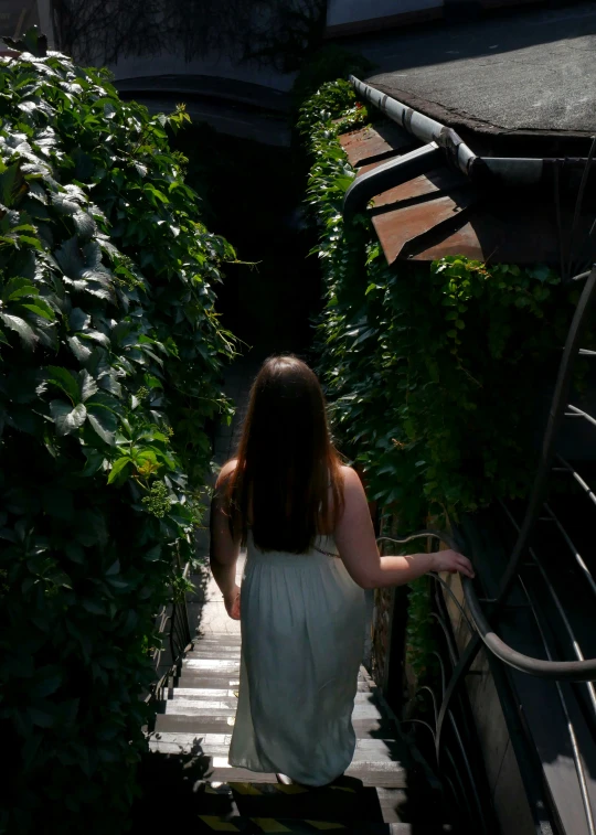 a woman in a white dress standing on a stair way