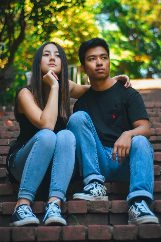a couple poses for a picture on a brick bench