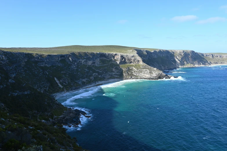 a wide cliff next to a large body of water