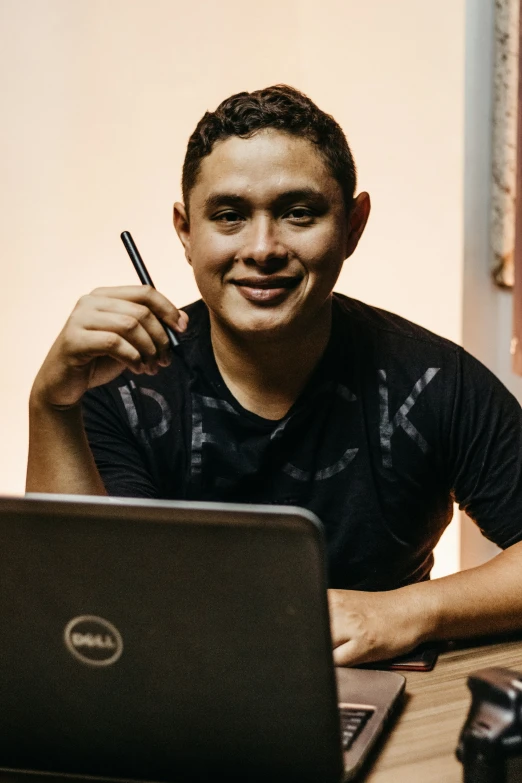 a man sitting at a desk with a laptop on his lap