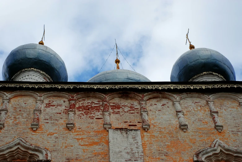 two dome type buildings with blue roofs on a cloudy day