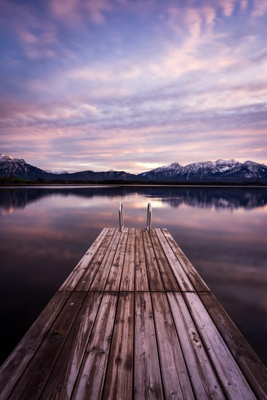 a very long wooden pier in front of the water