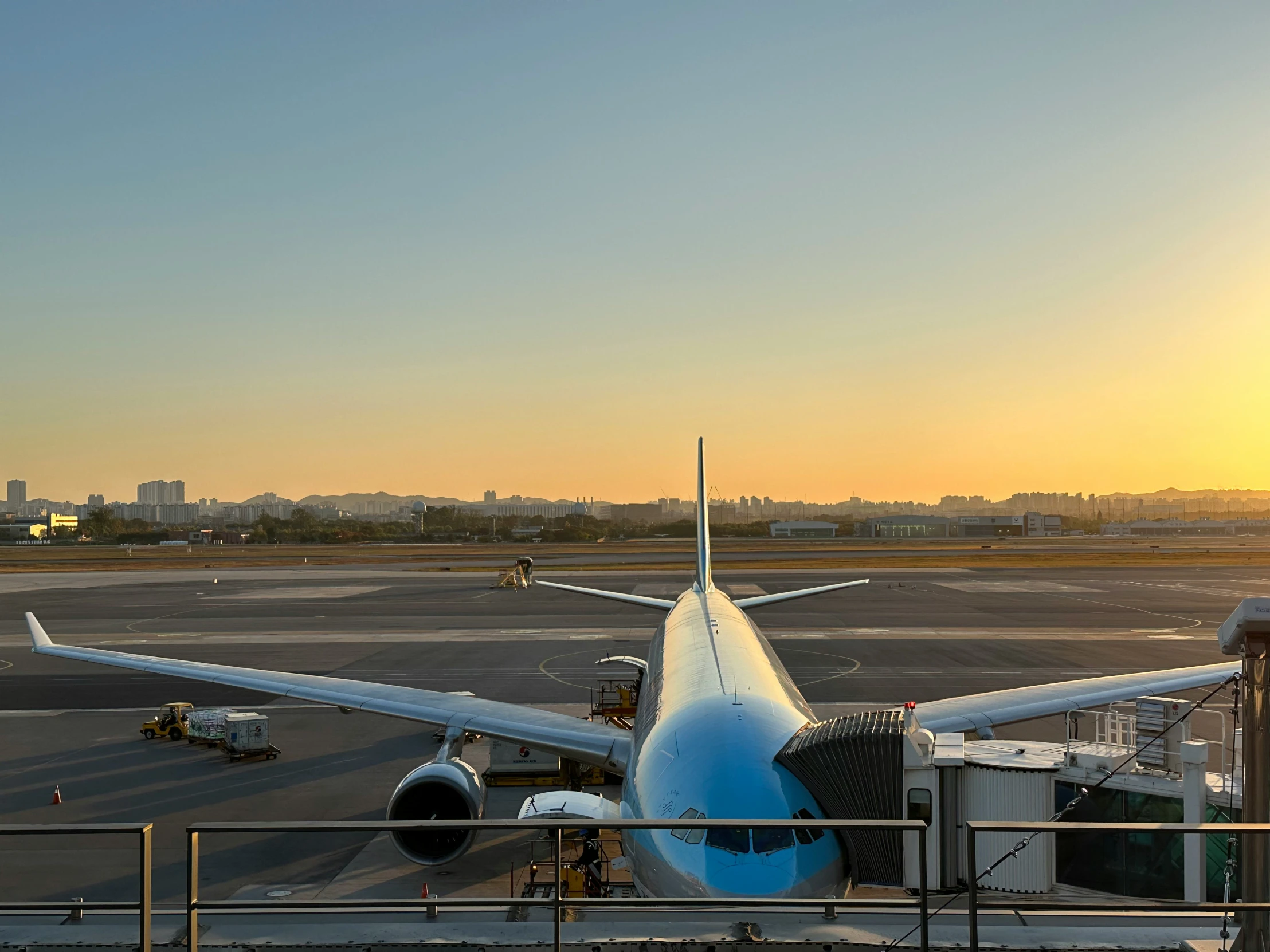 a plane at an airport in front of a sunset