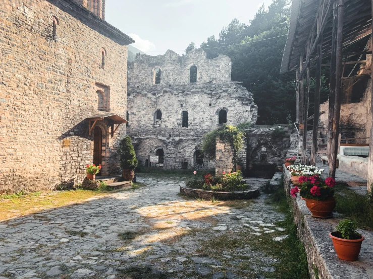 an old stone building with some potted flowers in front of it