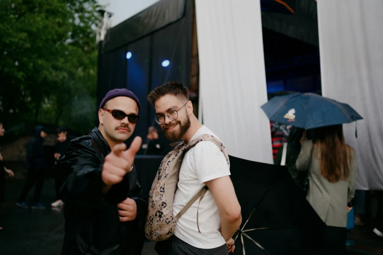 two men giving the thumbs up and an umbrella open to the pographer