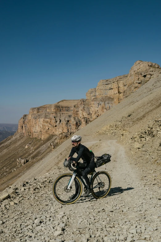 a man riding his mountain bike on a large rocky trail