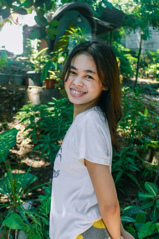 a beautiful asian girl standing in the middle of a forest