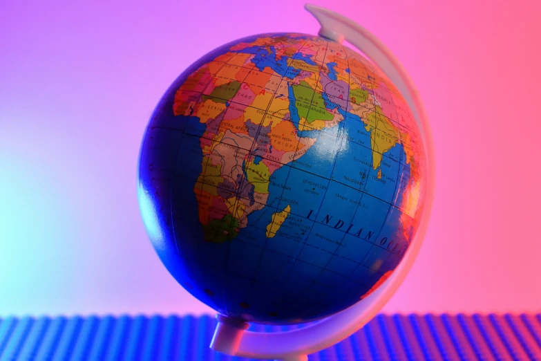 a blue and red globe with a rainbow background