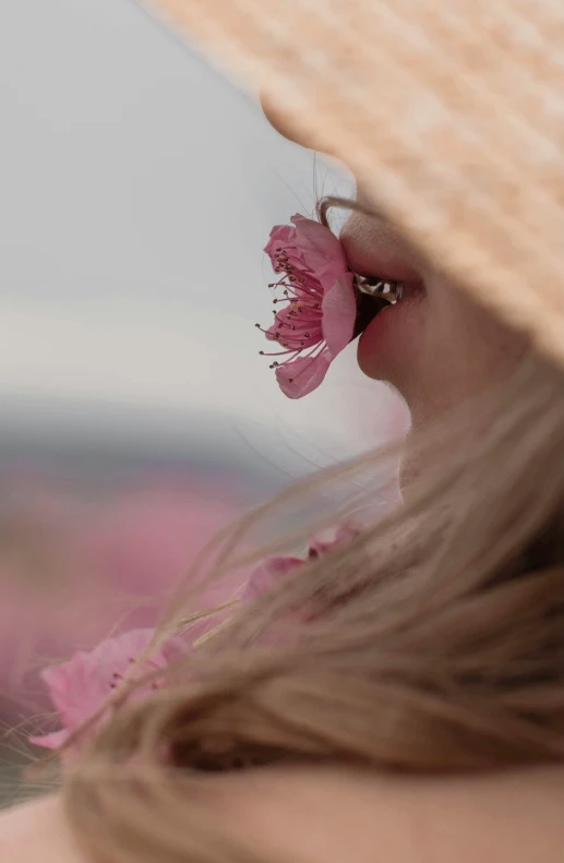 a person with a straw hat on is putting a flower in their hair