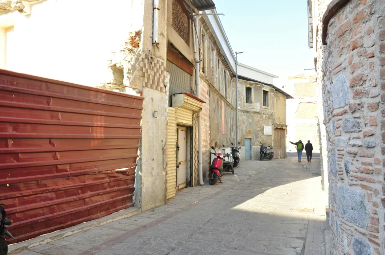 a narrow alley with scooters parked on the side