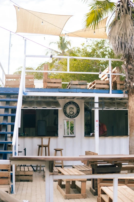 a group of wooden tables sitting under a flag