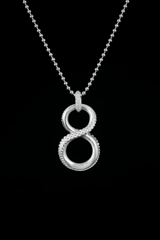 a white gold necklace on a black background