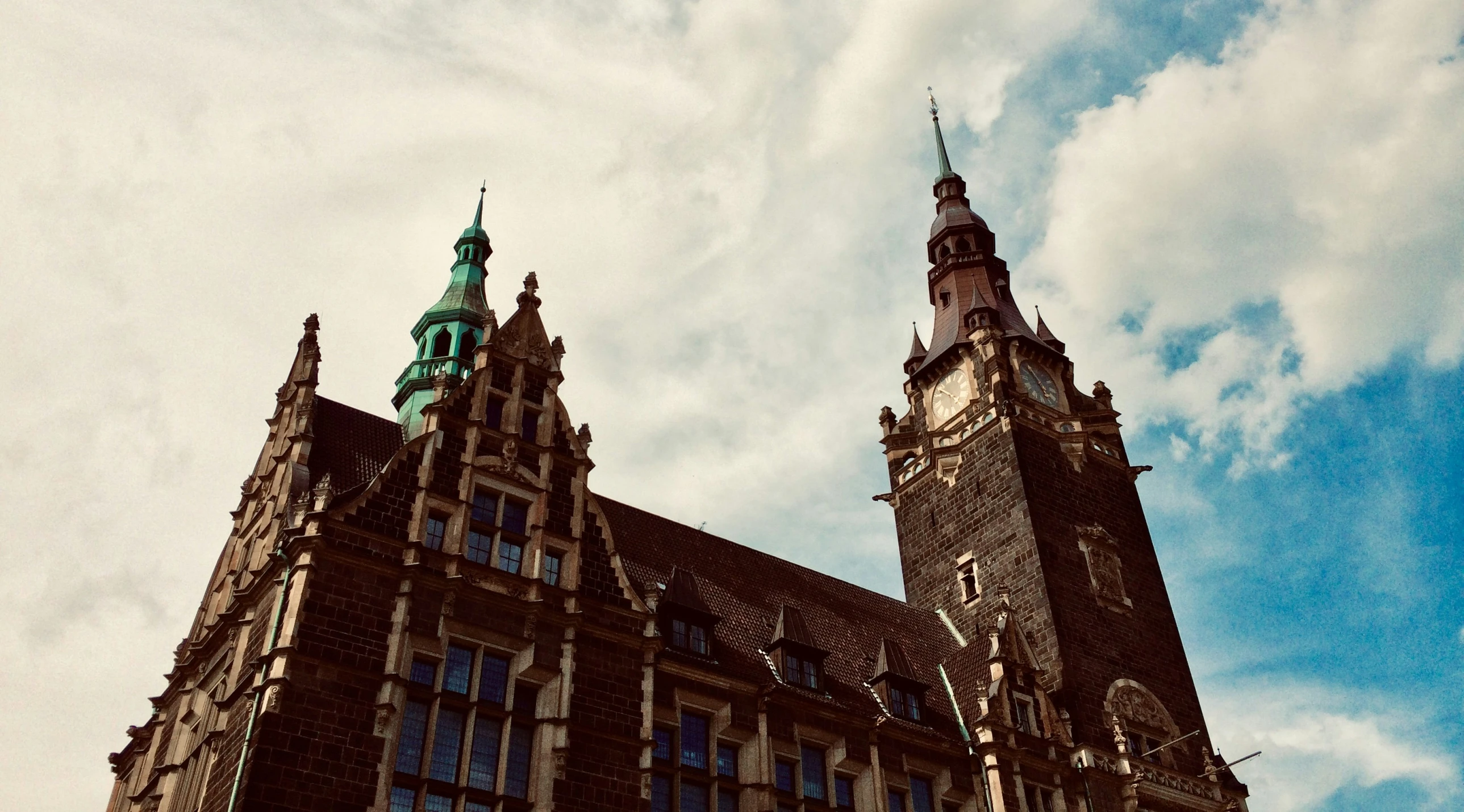 two towers of the building with clock are pictured