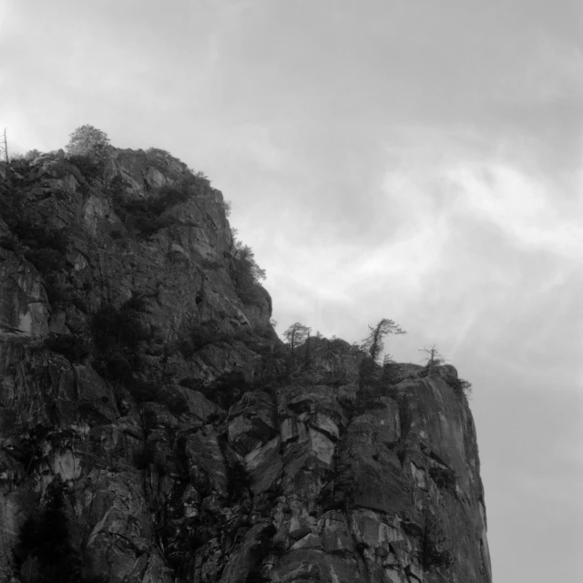 a steep rock with a cross on top