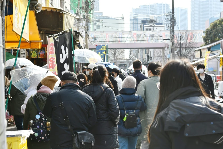 many people walk near the vendor on a busy city street