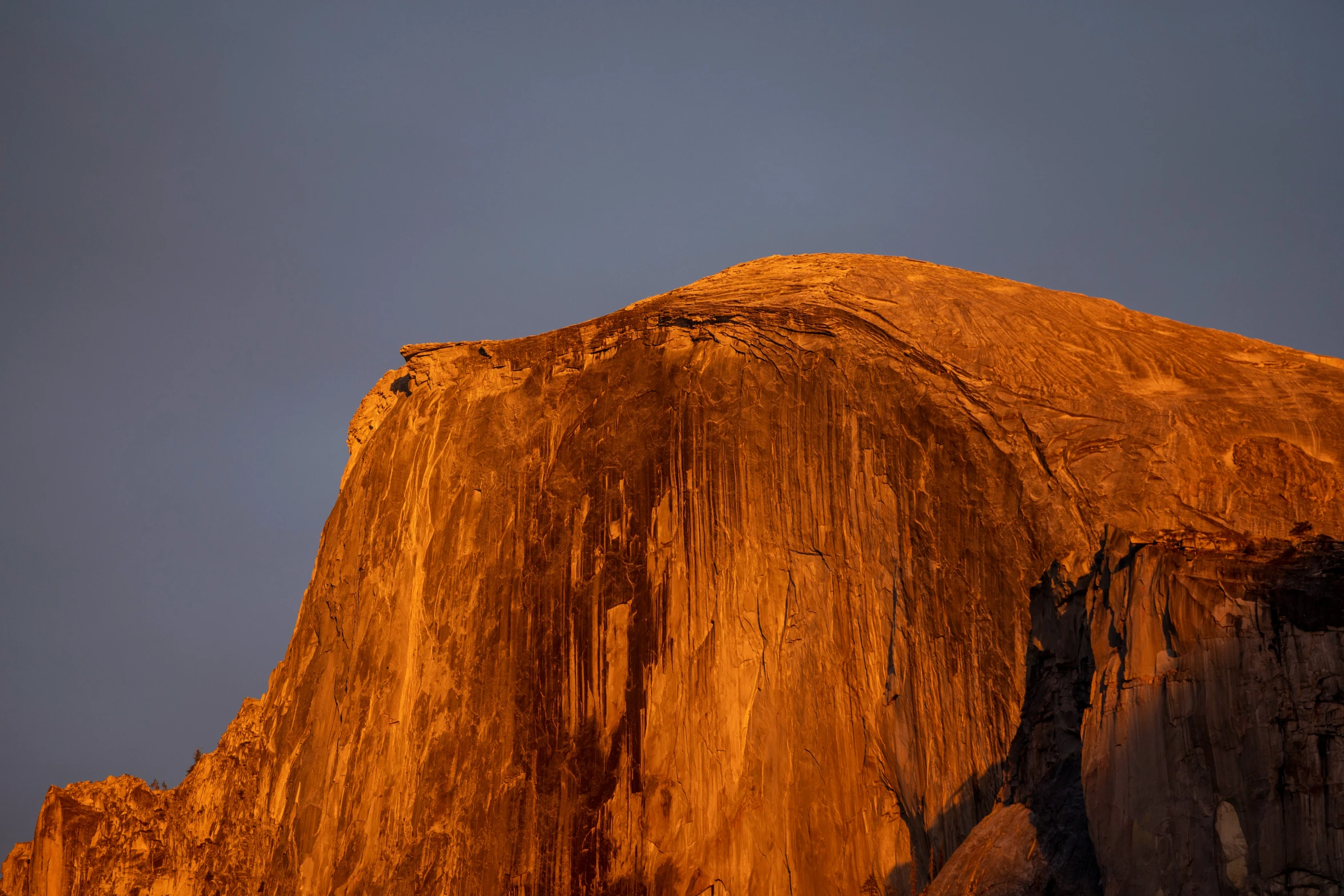 the sun is setting on the rock formation