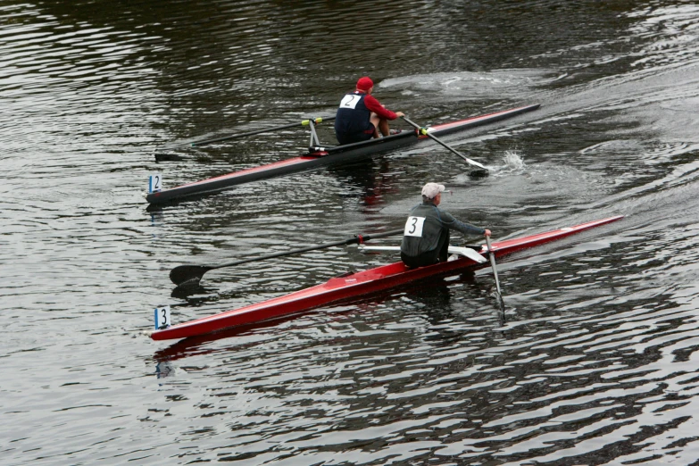 two men are rowing in a canoe on a lake