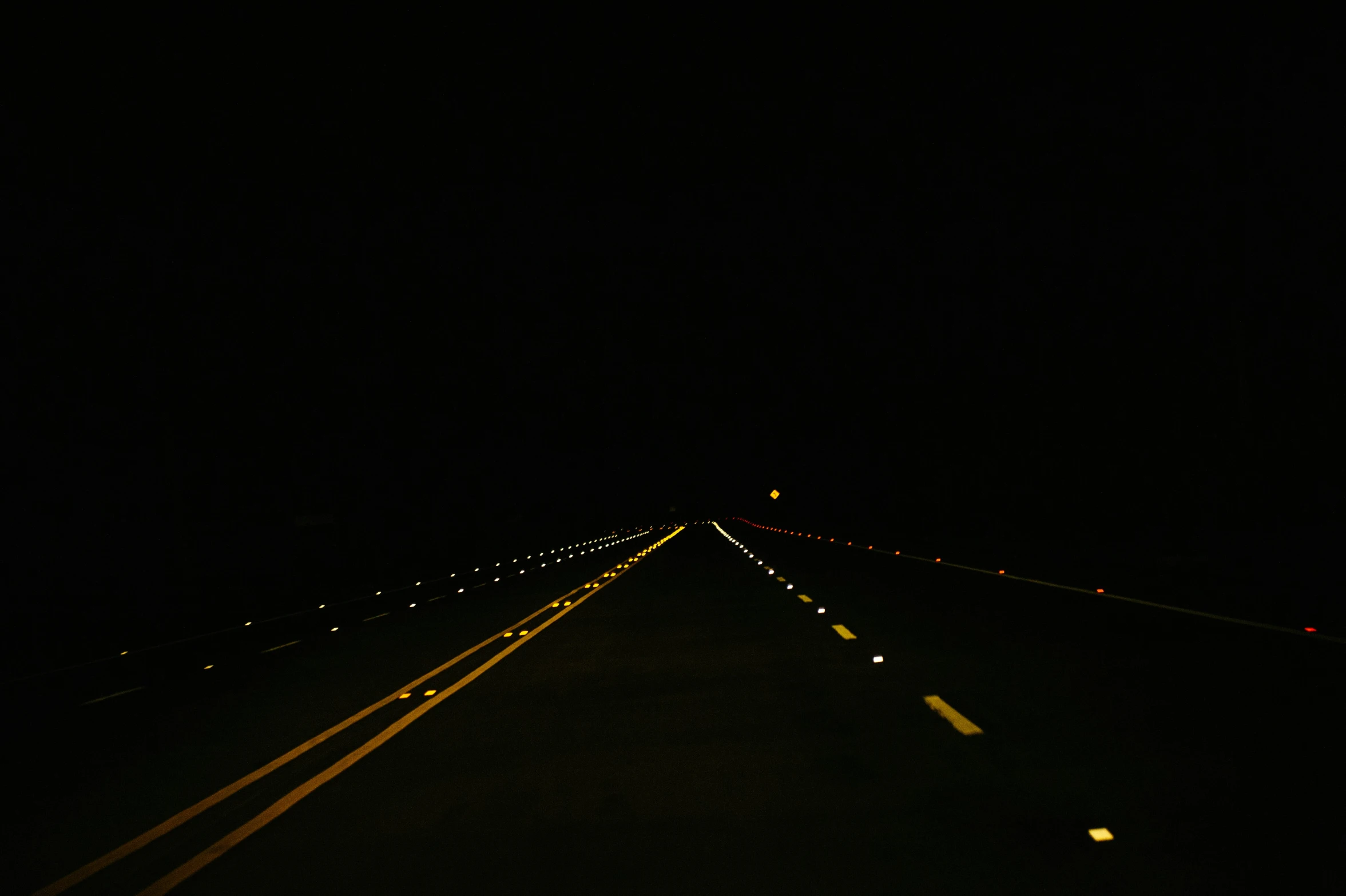 the empty highway is lit up at night