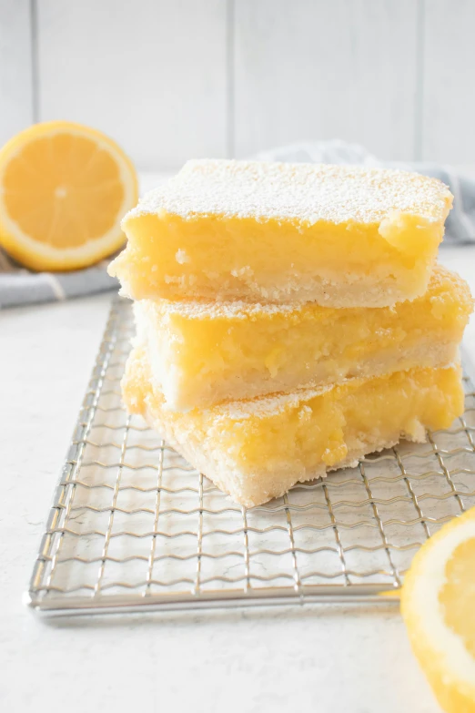 three slices of lemon bars sit on a cooling rack