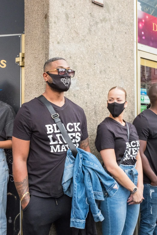 the men are standing together wearing masks on their face