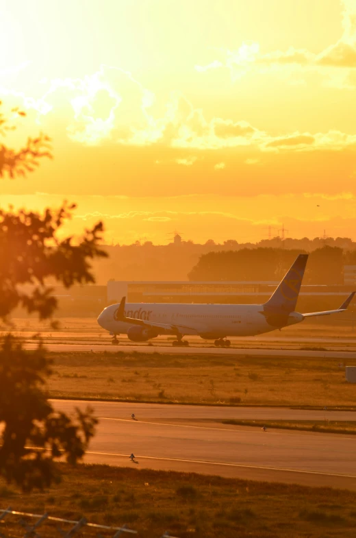 two airplanes sitting on an airstrip at sunset