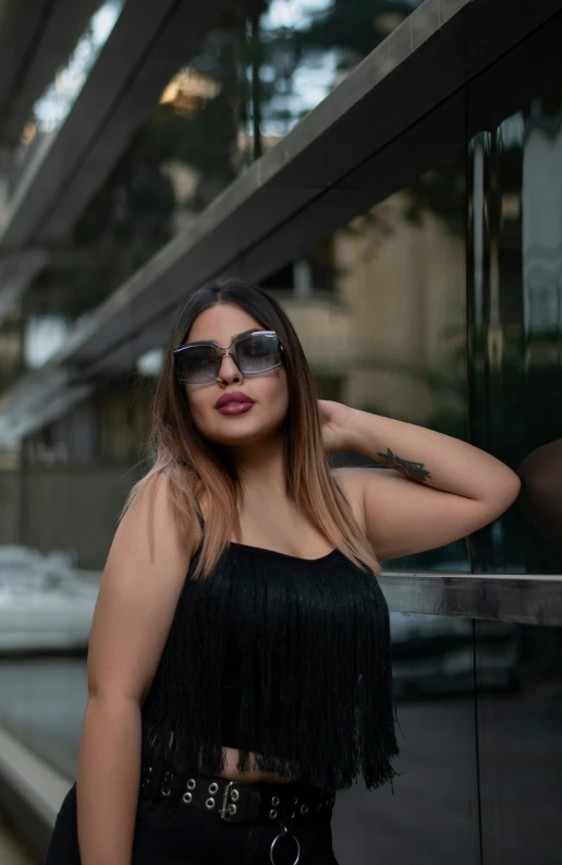 a girl in a black top posing on a balcony