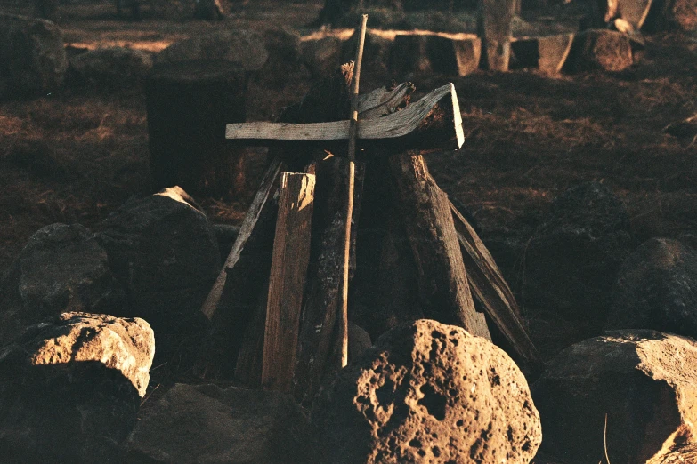 a rock pile with two wood poles near a wooden fence