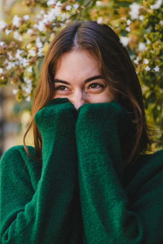 a woman's face has been covered with green sweatering