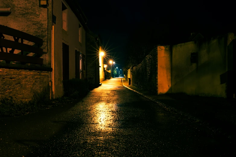 a dark city street has lights on in the night