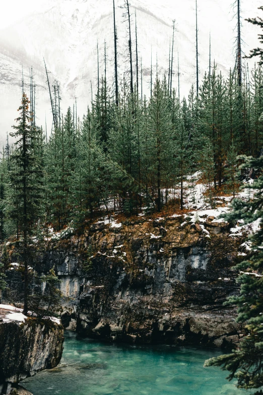 a view of a mountain and river in the snow
