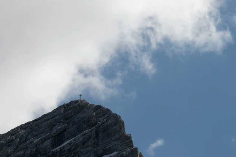 two birds flying near a steep rock formation