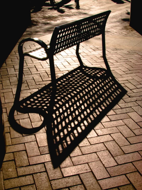 the shadows on the bench are almost all cast on