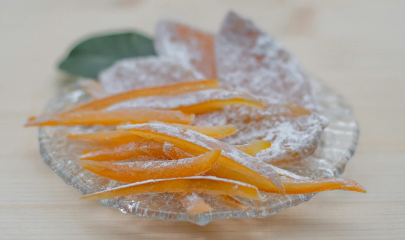 a frosted plate topped with oranges and powder