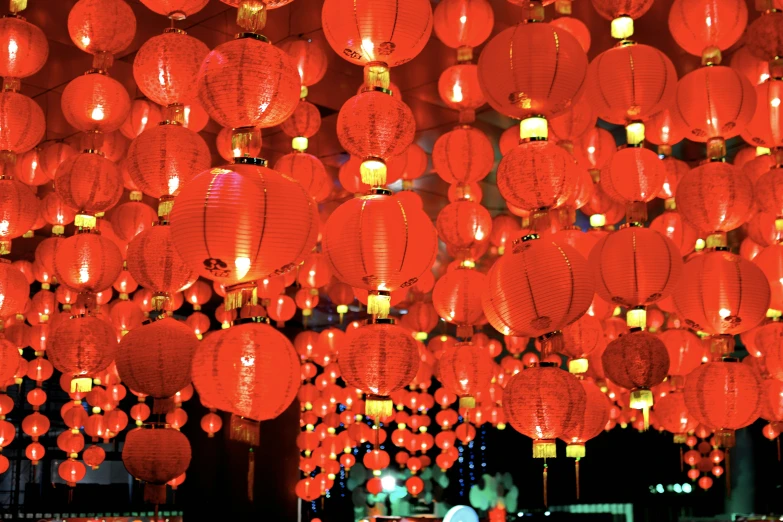 there are a lot of red lanterns hanging above the table