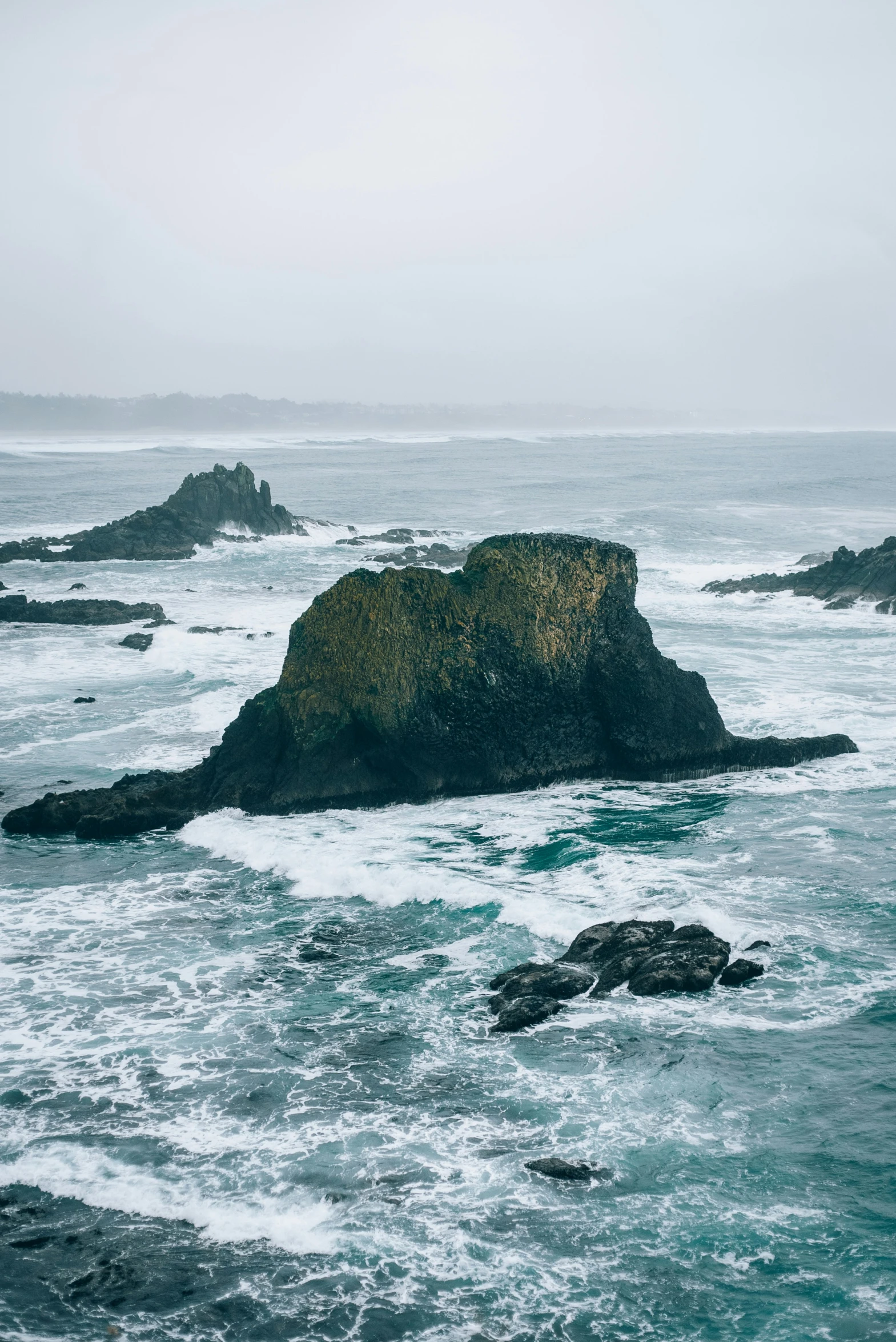 an island in the ocean with two large rocks next to it